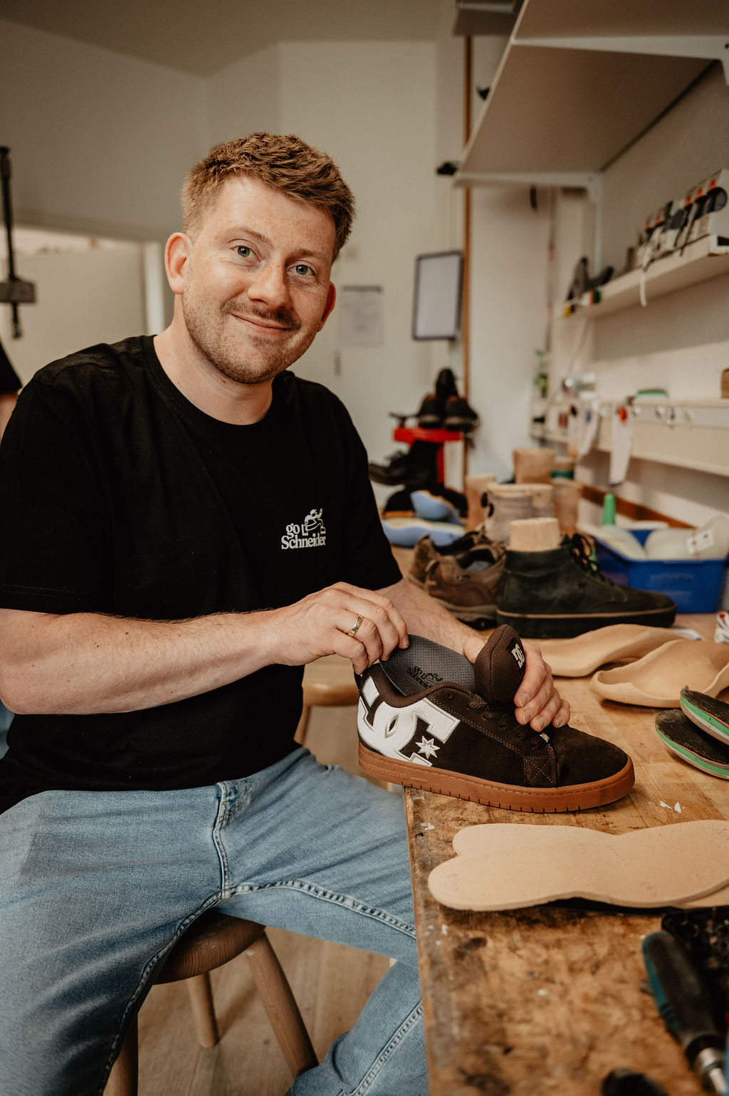 Dennis Schneider mit einem Schuh in der Werkstatt